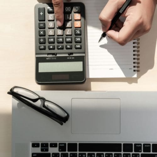 Calculatrice sur un bureau avec un ordinateur et une paire de lunette